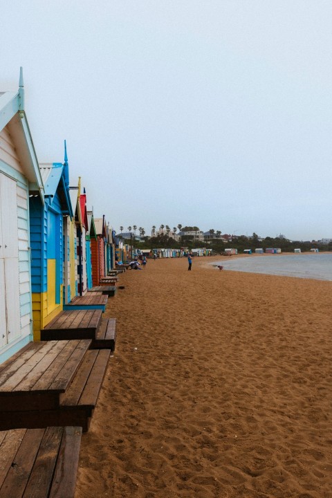 a row of beach huts sitting on top of a sandy beach