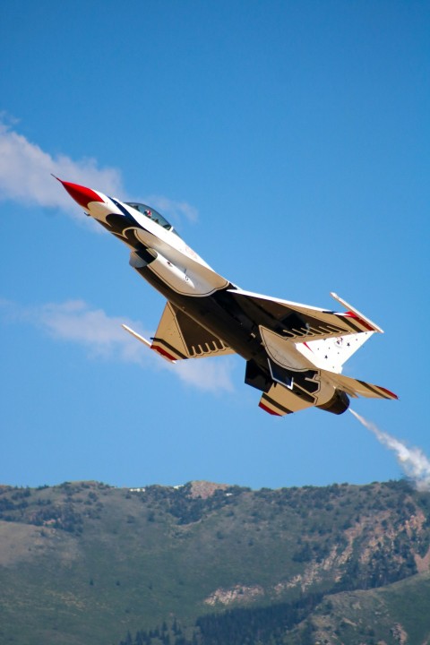 a fighter jet flying through a blue sky