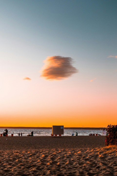 a beach at sunset with people walking on the sand