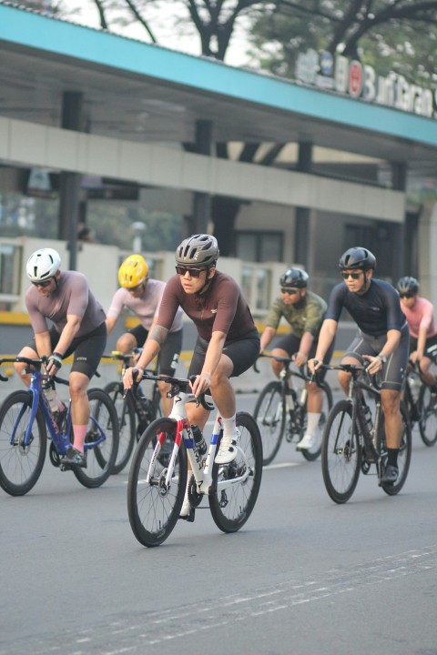 a group of men riding bikes down a street