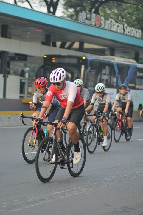 a group of people riding bikes down a street i