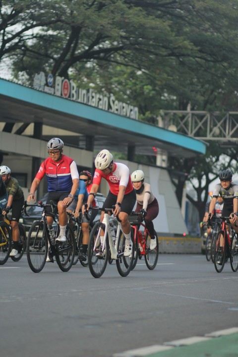 a group of people riding bikes down a street