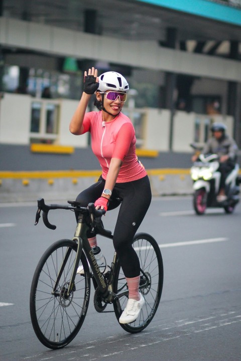 a woman riding a bike down a street