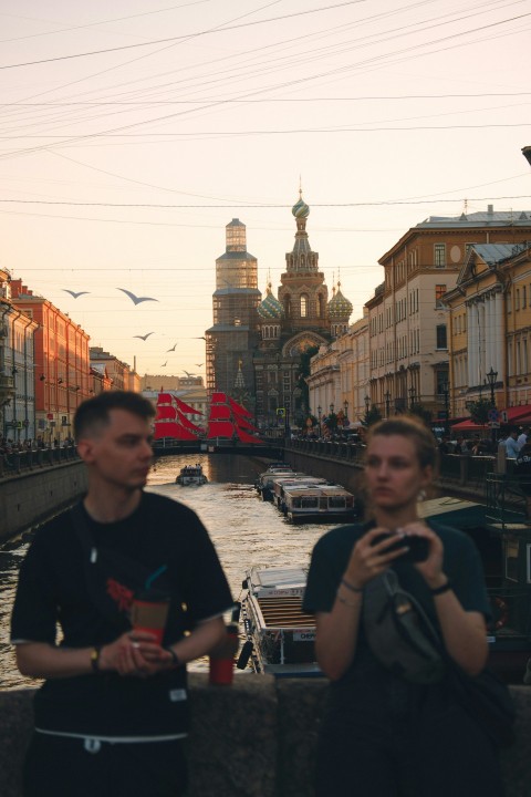 a couple of people standing next to a river