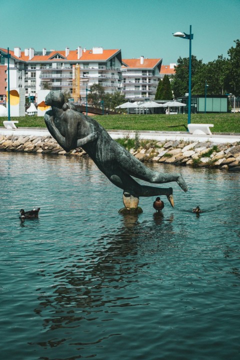 a statue of a dolphin swimming in a body of water