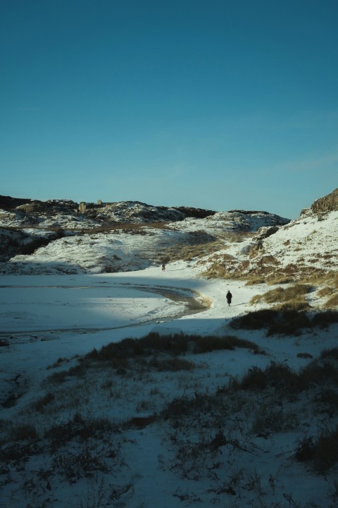 a person walking through a snow covered field VW