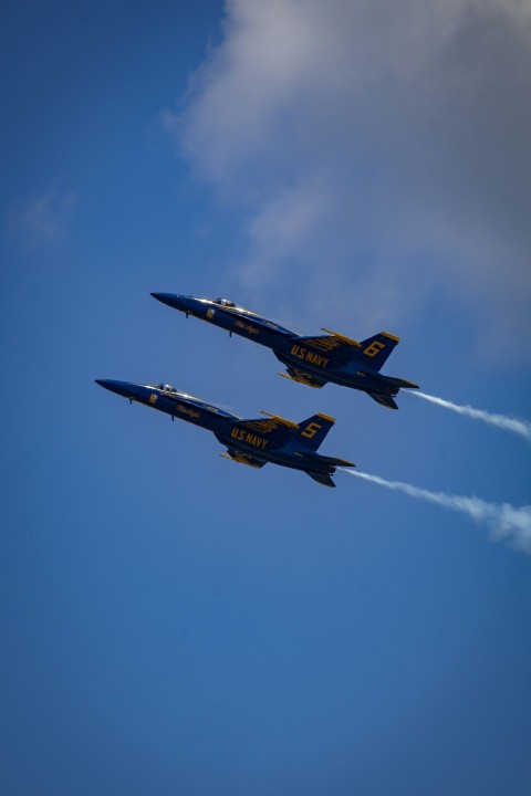 two fighter jets are flying in formation in the sky