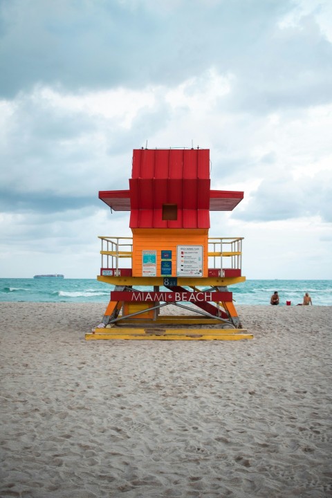 a lifeguard tower on a beach with people in the water