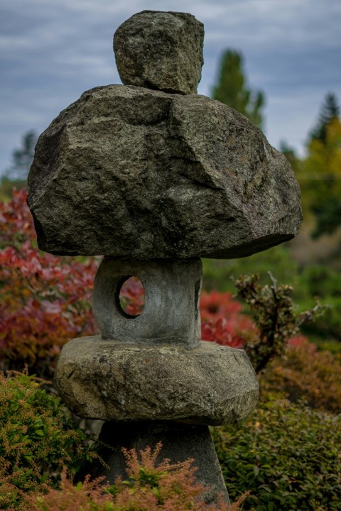 a large rock sitting on top of a lush green field