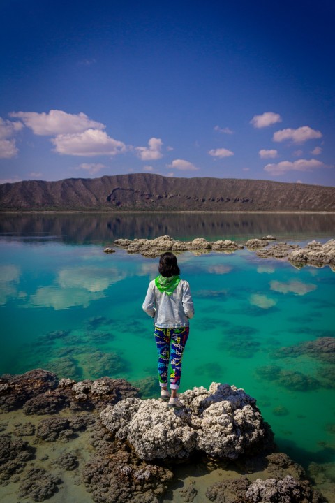 a person standing on a rock in the water