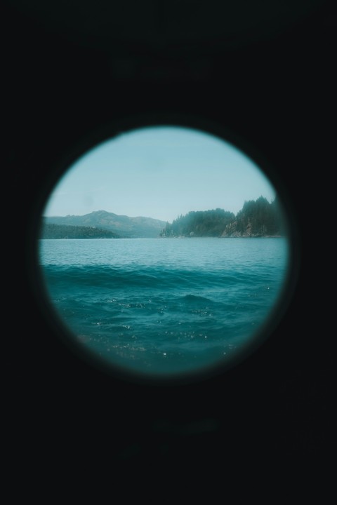 a view of a body of water through a porthole