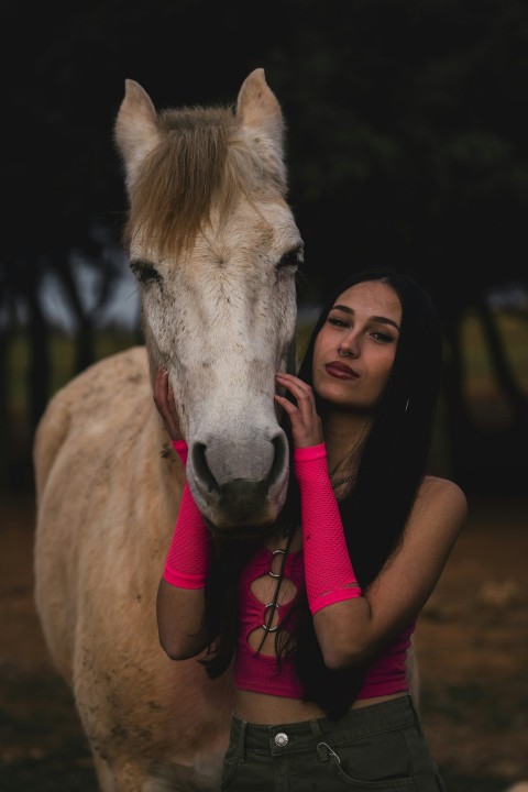 a woman standing next to a white horse s_sWKp