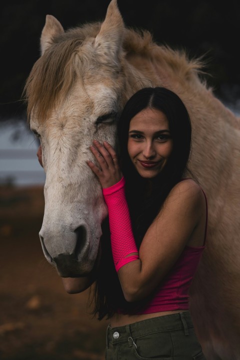 a woman hugging a horse in a field