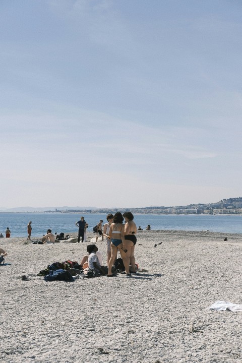 a group of people standing on top of a sandy beach