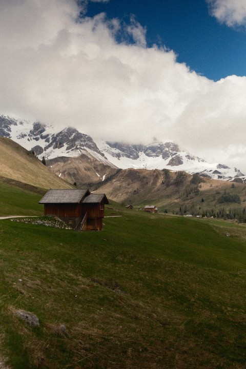 a grassy field with a house in the middle of it Khgox5bd