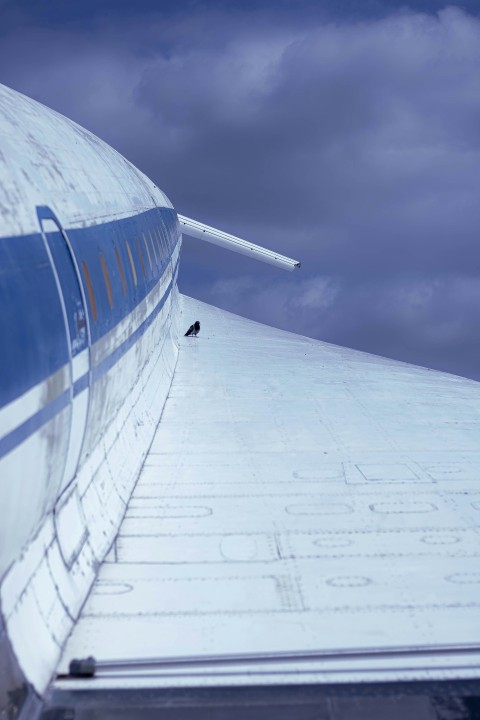 the tail end of an airplane against a cloudy sky