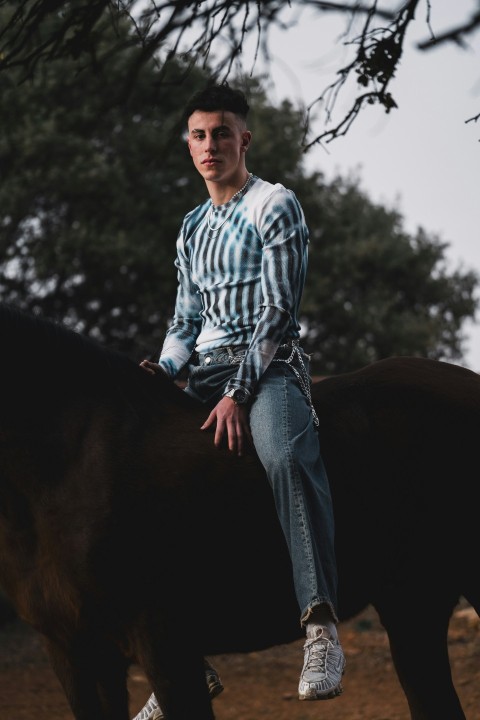 a man sitting on the back of a black horse