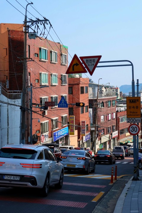 a city street filled with lots of traffic next to tall buildings