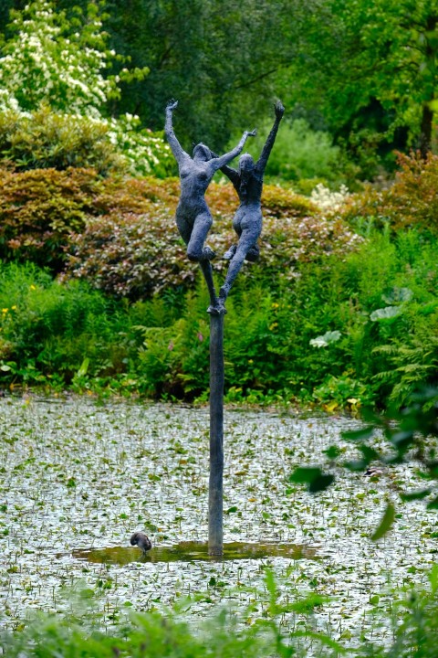 a statue of two people standing on top of a pole