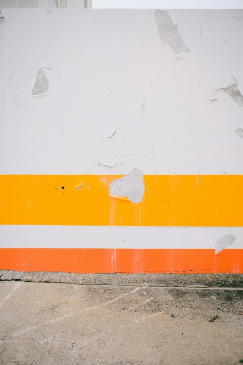 an orange and white striped wall with a fire hydrant