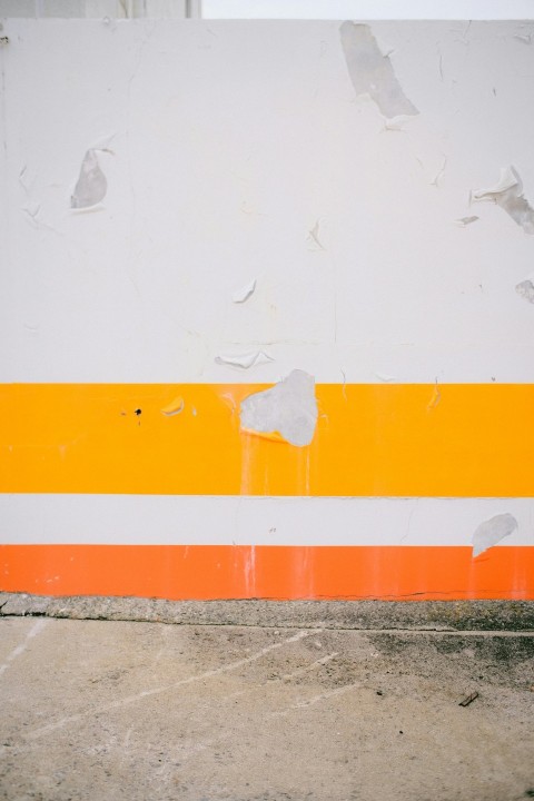 an orange and white striped wall with a fire hydrant
