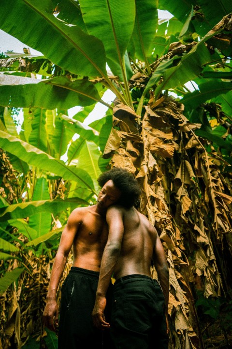 a couple of men standing next to each other in a forest zF_NuS6M7