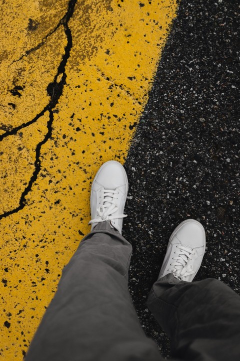 a person standing on a street with white shoes