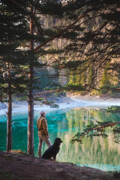 man in black jacket standing beside river during daytime l