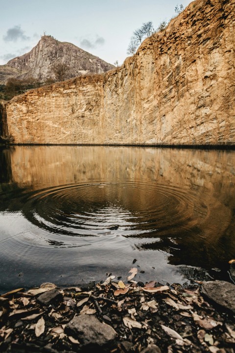 calm body of water surrounded by rock formations at daytime