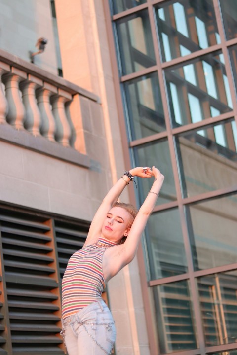 woman in red and white stripe tank top and black and white striped pants raising her gN_RcBbT