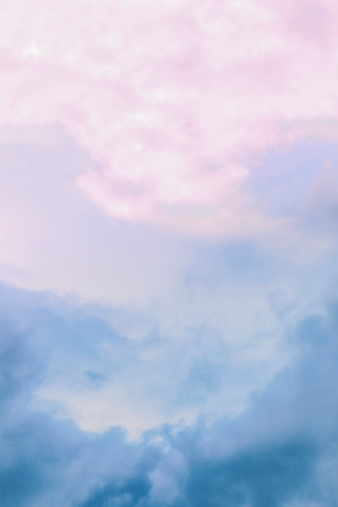 a plane flying through a cloudy blue sky