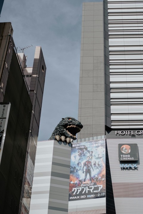 a tall building with a godzilla statue on top of it