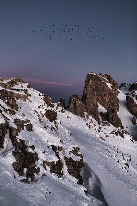 brown rocky mountain covered by snow under blue sky during daytime