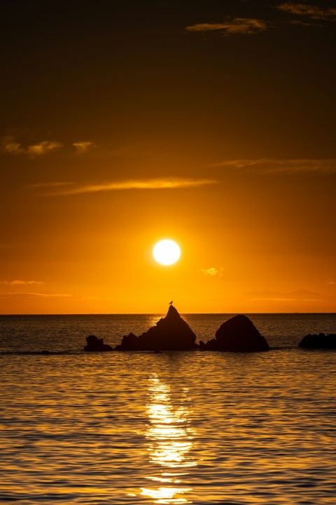 a large body of water with a sunset in the background