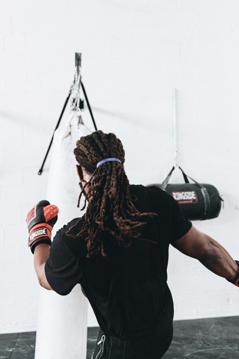 man in black crew neck t shirt wearing red and black boxing gloves