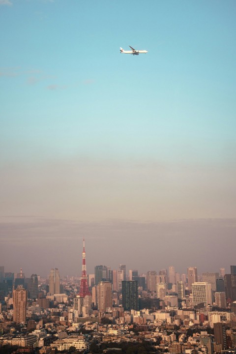 an airplane flying over a city with tall buildings