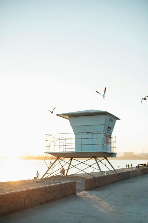 white wooden lifeguard house on beach during daytime