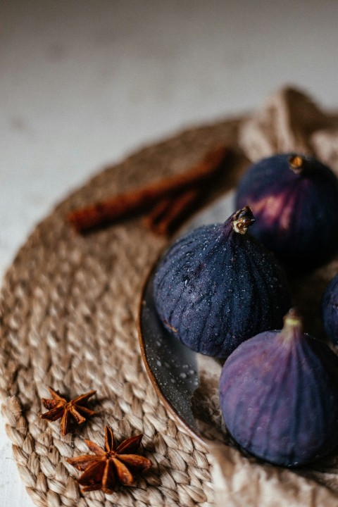 a plate topped with figs and anise on top of a table IEHfAYTfZ