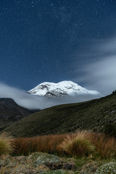 a snow covered mountain under a night sky