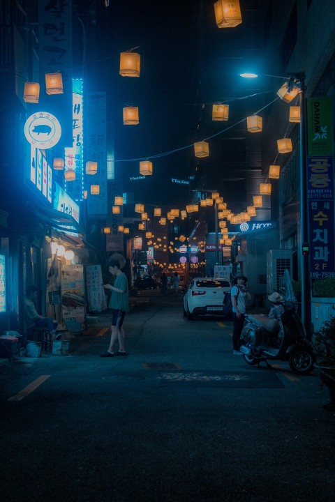 man standing on street while holding smartphone