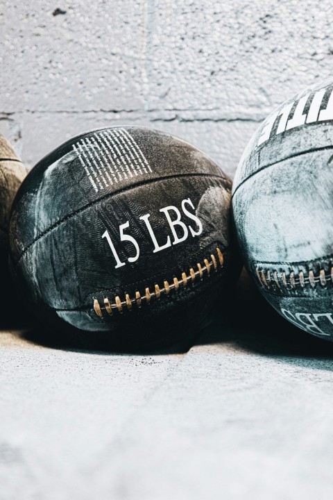 three old worn out baseballs sitting on the ground