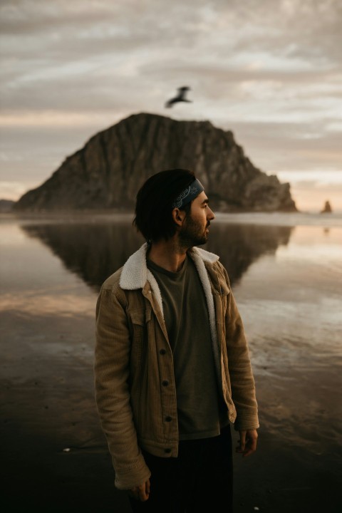 a man standing in front of a body of water _vnKbf9K