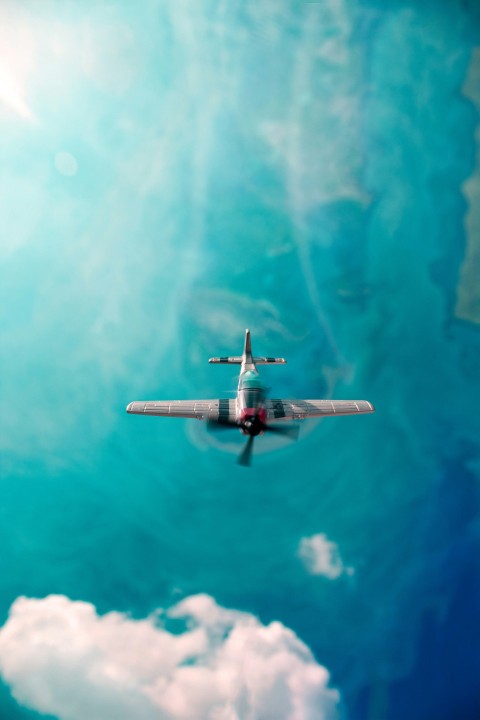 an airplane flying through a blue cloudy sky