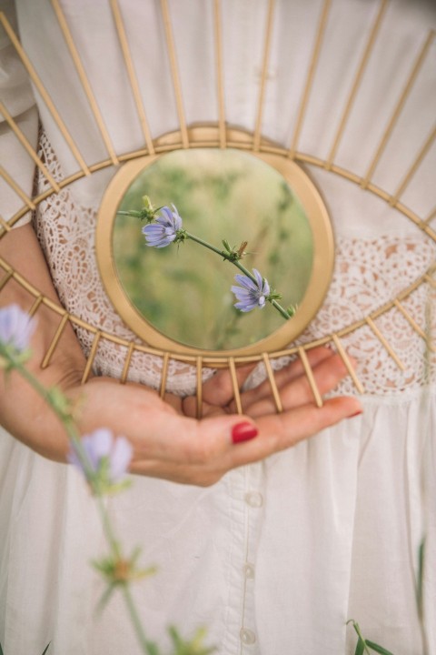 person holding gold framed round mirror n3NTCDsjV