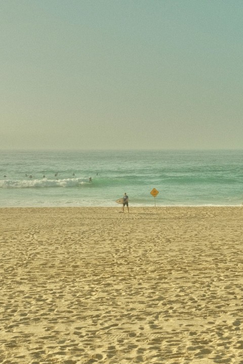 a person standing on a beach with a surfboard