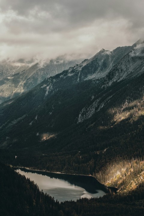 body of water between snow covered mountains