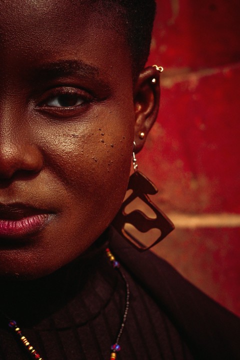 a close up of a person wearing a necklace and earrings