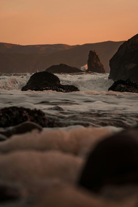 a view of the ocean with rocks in the foreground QI_n