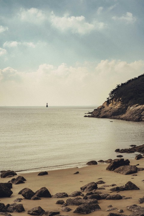 a rocky beach with a body of water and a rocky shore