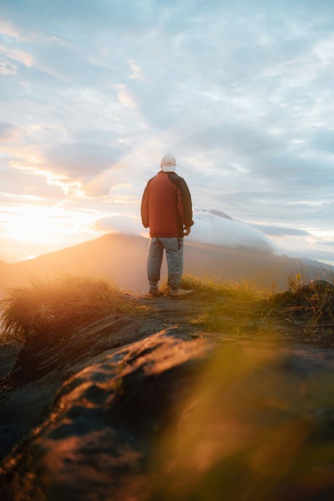 a man standing on top of a lush green hillside